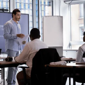 Formateur en formation professionnelle devant écran numérique dans salle de classe moderne.