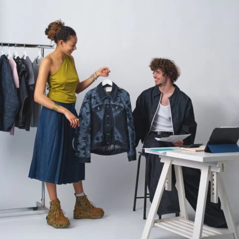 Présentation dune veste denim imprimée par deux créateurs en atelier de stylisme.