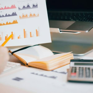 Analyse de données au bureau : graphiques, rapports, ordinateur portable et calculatrice.