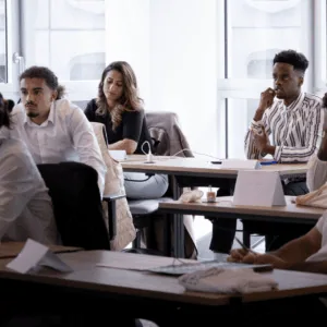 Salle de formation moderne pour atelier et réunion, participants, tables, chaises ergonomiques, grandes fenêtres.