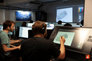 Studio créatif collaboratif avec tablettes graphiques, écrans et projection de dessin numérique.