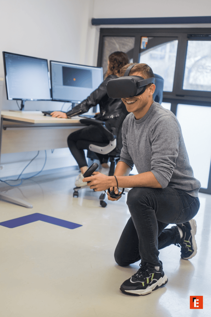 Test de réalité virtuelle en studio : développeur avec casque VR et contrôleurs au bureau.