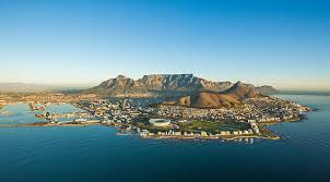 Vue aérienne panoramique dune ville-péninsule dominée par une montagne-table et son port.