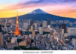 Ville moderne au coucher de soleil avec tour orange et volcan enneigé en arrière-plan.