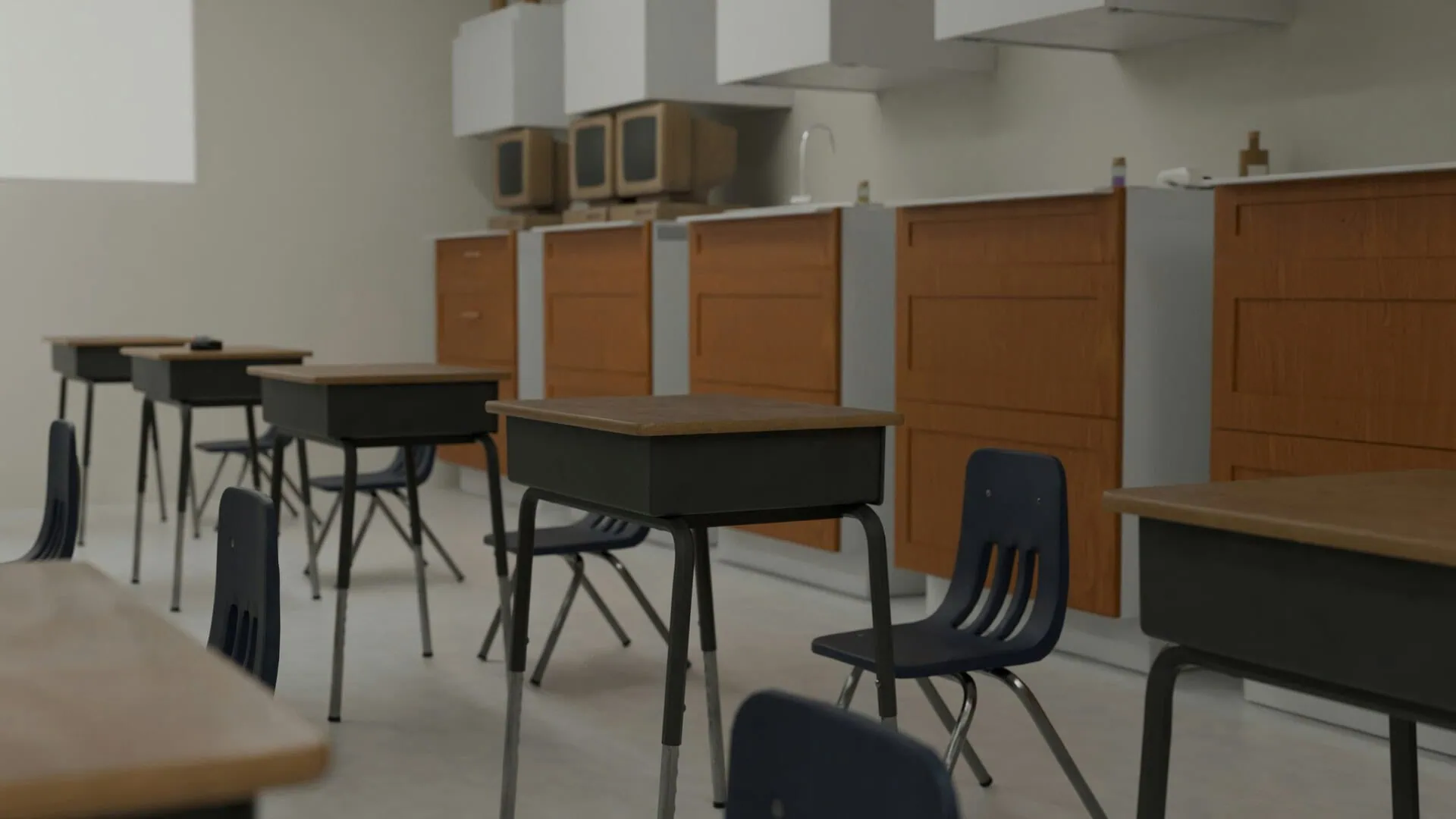 Classe vide avec rangée de pupitres et chaises en plastique, armoires et écrans en arrière-plan.