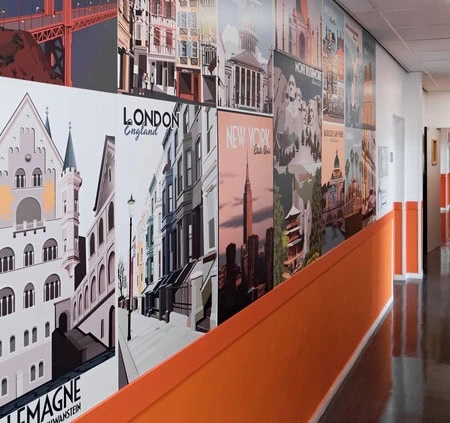 Couloir moderne avec murale de voyage, reflets brillants et silhouette lointaine.