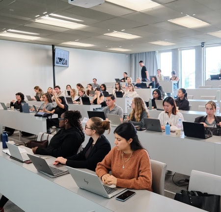 Amphithéâtre universitaire rempli détudiants avec ordinateurs portables pendant un cours numérique.