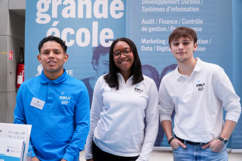 Équipe au stand de promotion dune grande école, étudiants en marketing, finance et digital.