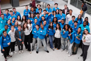 Photo aérienne du groupe détudiants EMLV en polos bleus dans latrium.