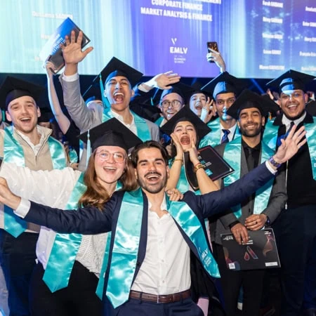 Remise de diplômes : grand groupe détudiants en toques et écharpes turquoises célébrant.
