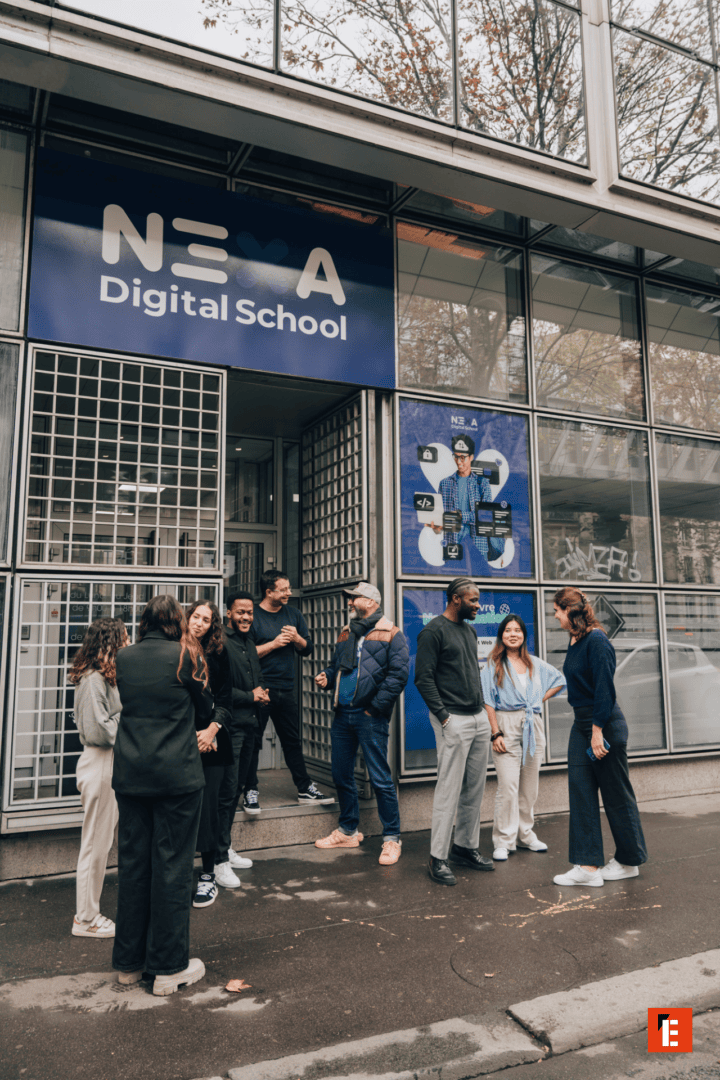 Entrée école numérique NEA, façade vitrée bleue et groupe détudiants.