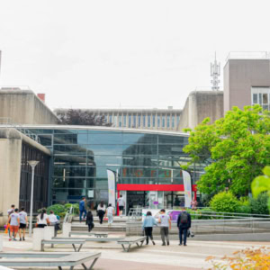 Entrée du campus Télécom SudParis, bâtiment brutaliste avec atrium vitré.