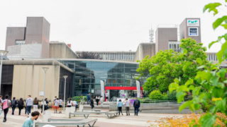 Entrée du campus Télécom SudParis, bâtiment brutaliste avec atrium vitré.