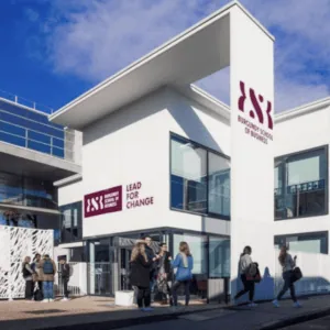 Entrée moderne du campus de lÉcole de commerce de Bourgogne avec vélos et étudiants.