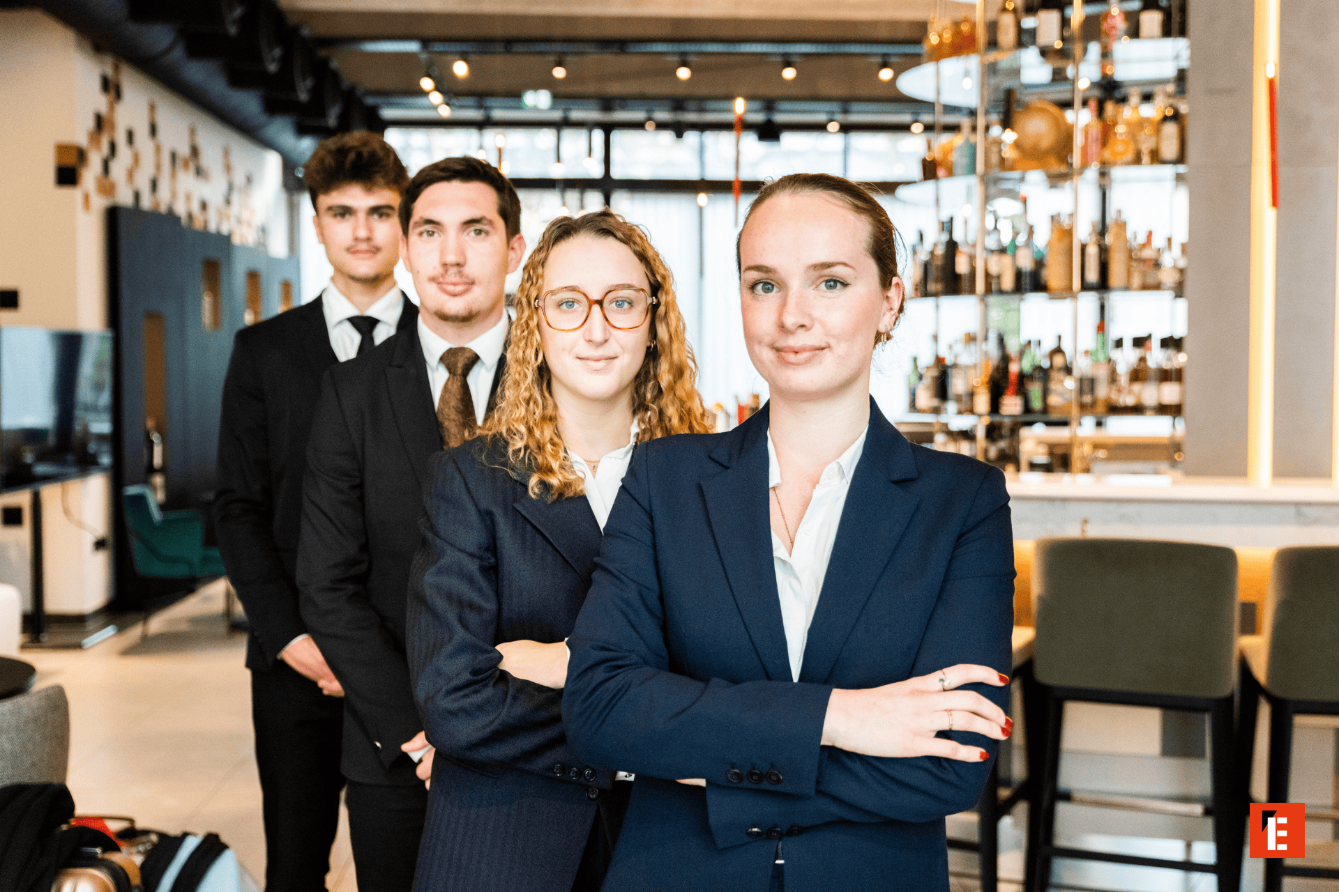 Équipe professionnelle dhôtel en uniforme devant bar moderne, personnel de service attentif.