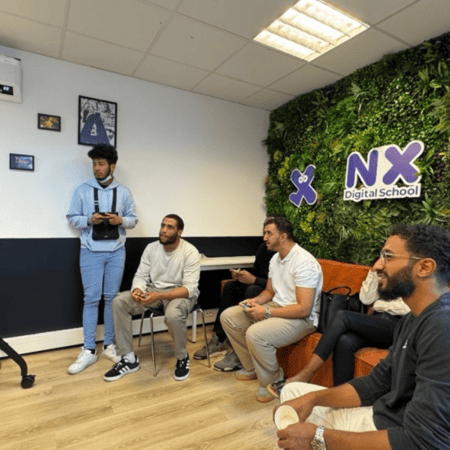 Groupe jouant à des jeux vidéo sur grand écran TV dans salle moderne Digital School.