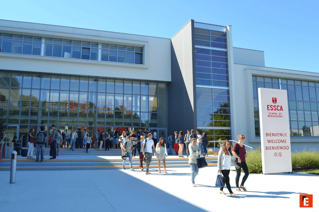 Entrée du campus ESSCA, bâtiment moderne vitré avec étudiants et cour ensoleillée.