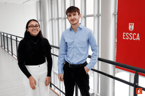 Deux étudiants ESSCA dans un couloir lumineux aux grandes fenêtres.