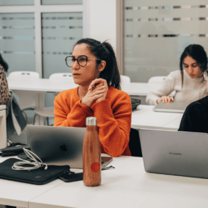 Groupe détudiants en espace de travail moderne, ordinateurs portables et ambiance studieuse.
