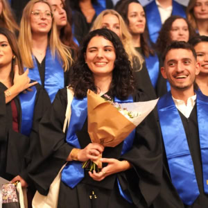 Photo de groupe détudiants diplômés en stoles bleues souriants, cérémonie.