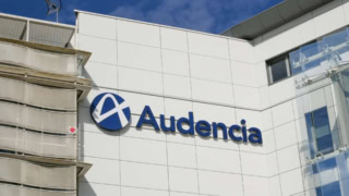Façade Audencia avec enseigne bleue sur panneaux blancs et façade vitrée.