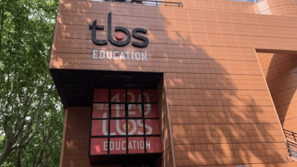 Façade TBS Éducation en terre cuite, logo et vitrine moderne.