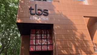 Façade TBS Éducation en terre cuite, logo et vitrine moderne.