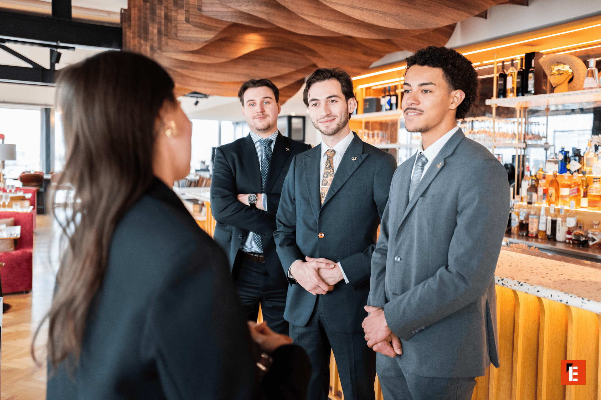 Groupe dhommes en costume au bar dhôtel, discussion professionnelle dhospitalité.
