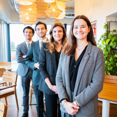 Groupe de jeunes professionnels en café coworking lumineux, équipe business moderne et conviviale.