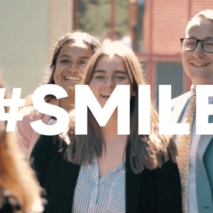 Groupe de personnes souriantes prenant un selfie pour réseaux sociaux.