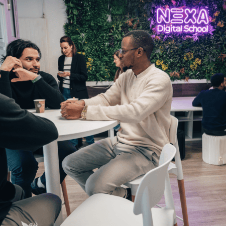 Espace apprentissage Nexa École Digitale, étudiants en coworking avec café, mur végétal et néon.