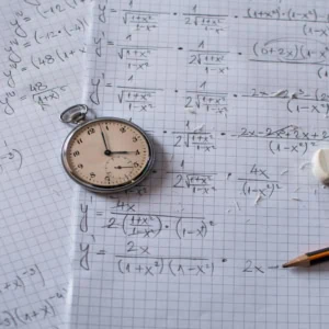 Montre à gousset sur papier millimétré couvert de calculs mathématiques, crayon et gomme.
