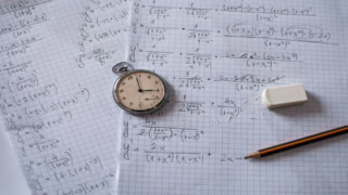 Montre à gousset sur papier millimétré couvert de calculs mathématiques, crayon et gomme.