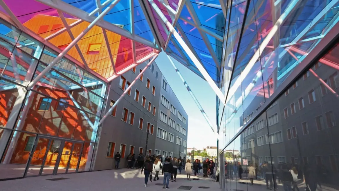 Passage urbain moderne à vitraux colorés, reflets en verre et flux de piétons.