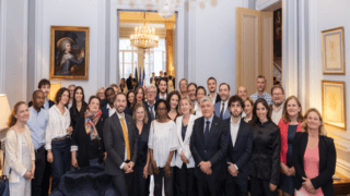 Photo de groupe formelle dans un intérieur élégant avec lustre, portrait et tenues professionnelles.