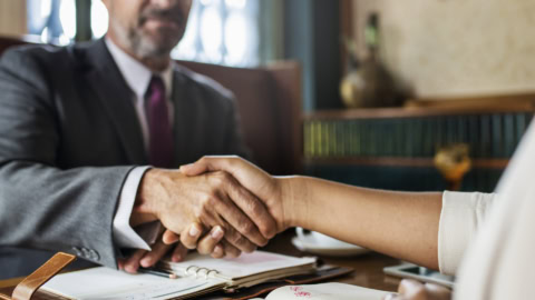 Poignée de main professionnelle au bureau, accord commercial entre partenaires en costume.