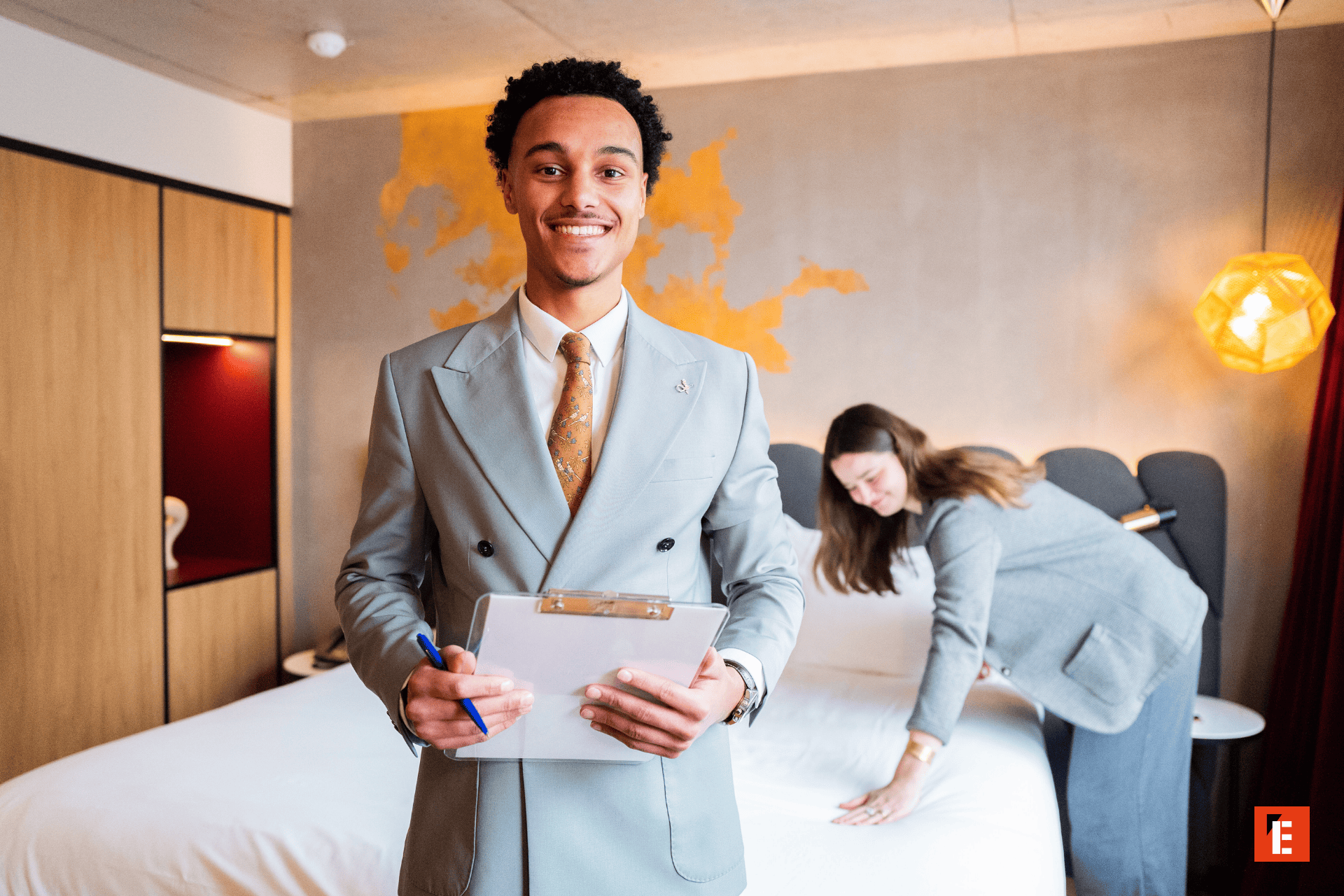 Préparation chambre dhôtel : personnel souriant, bloc-notes et lit impeccables.