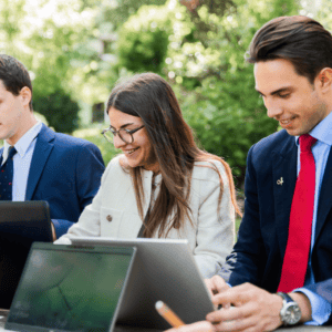 Professionnels en équipe travaillant en extérieur sur ordinateurs portables, collaboration et productivité.