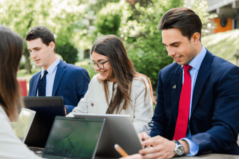 Professionnels en équipe travaillant en extérieur sur ordinateurs portables, collaboration et productivité.