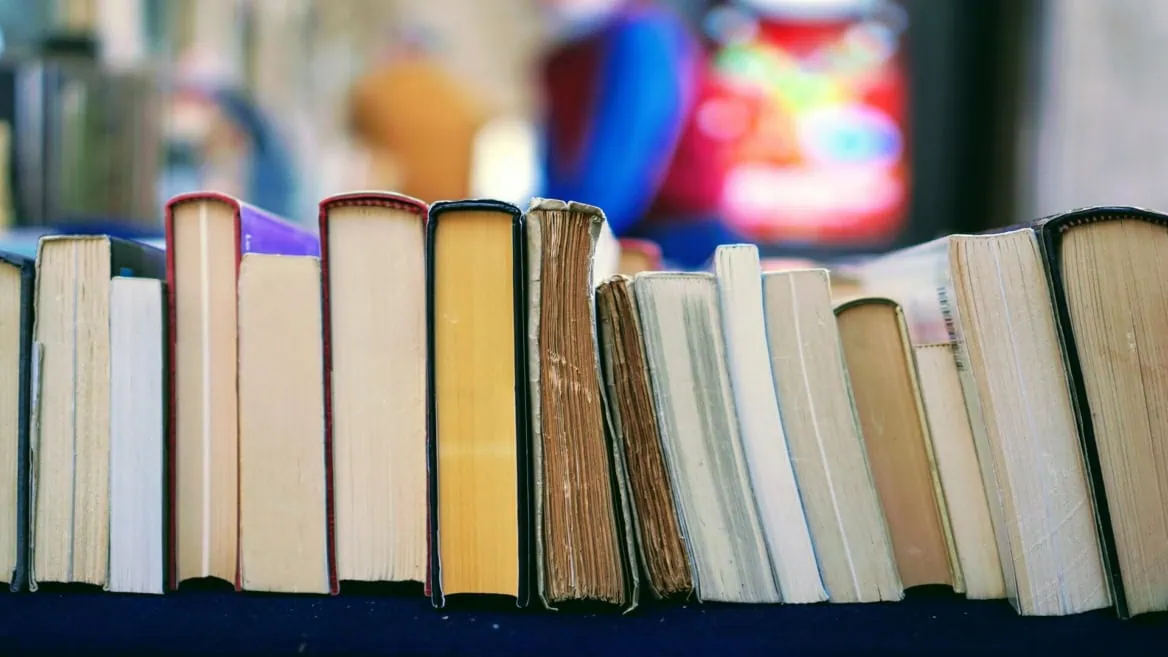 Rangée de livres anciens et modernes, bords de pages jaunies, texture pour bibliothèque.