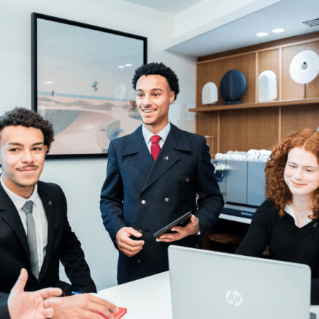 Réunion déquipe en bureau moderne avec ordinateur portable, présentation et participants souriants.