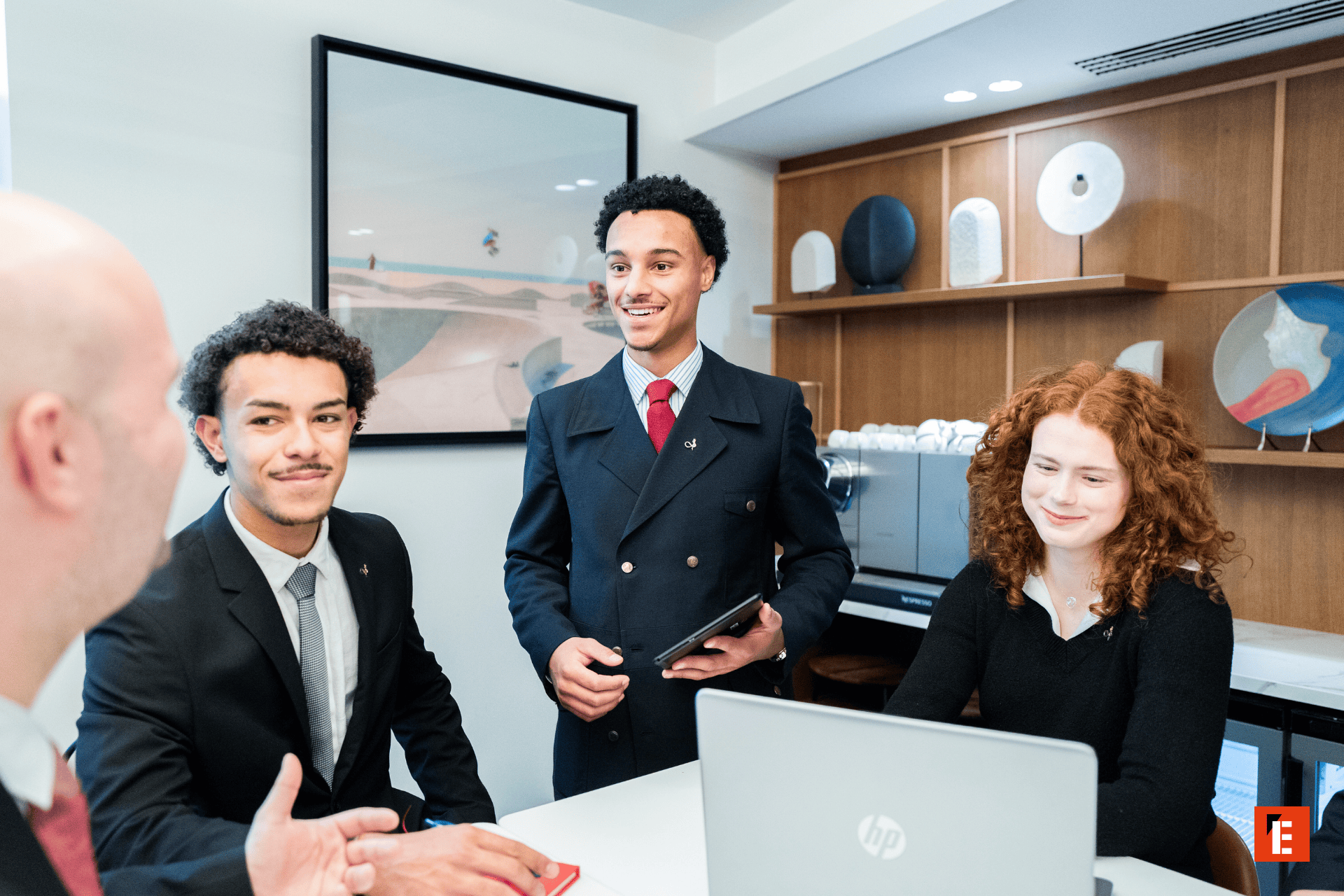 Réunion déquipe en bureau moderne avec ordinateur portable, présentation et participants souriants.