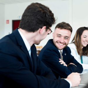Réunion déquipe professionnelle en bureau, collègues souriants collaborant autour dun ordinateur.