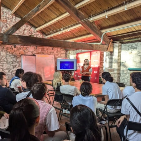 Atelier de présentation en loft rustique avec groupe, présentateur et écran.