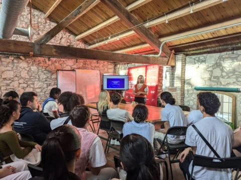 Atelier de présentation en loft rustique avec groupe, présentateur et écran.