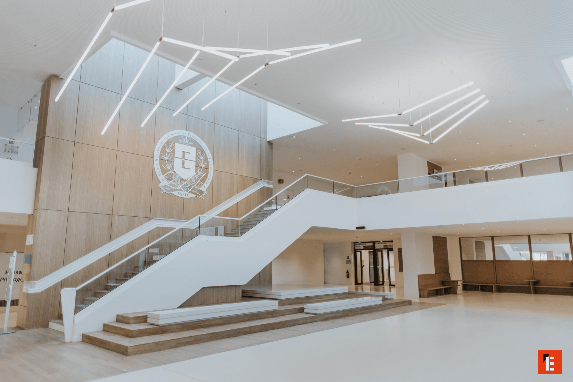 Atrium minimaliste en bois, design contemporain, escalier, mezzanine vitrée et lumière naturelle.