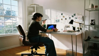 Bureau à domicile lumineux avec ordinateur portable, plantes, espace de télétravail organisé.