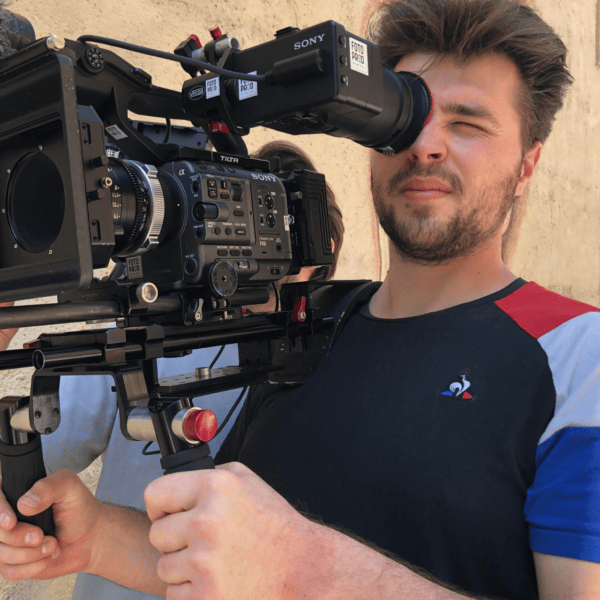 Opérateur cinéma tenant caméra Sony sur épaules avec rig professionnel et matte box.