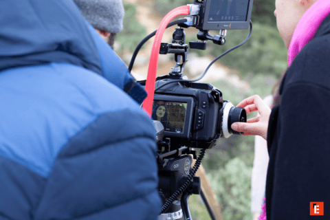 Caméra cinéma pro sur trépied, équipe de tournage ajustant le suivi de mise au point.