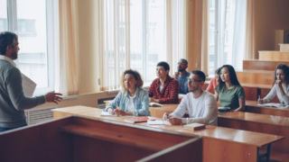 Cours universitaire en salle lumineuse avec professeur et étudiants attentifs.